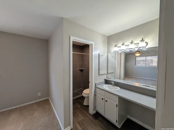 a spacious bathroom with a double vanity sink a large mirror and a shower
