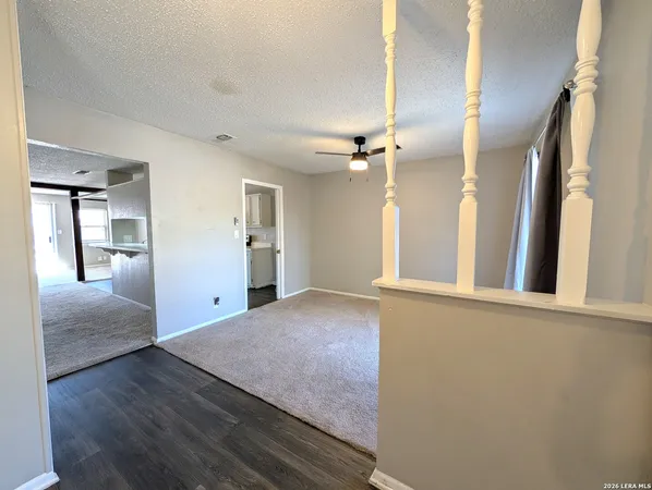 a view of a hallway with wooden floor and cabinet
