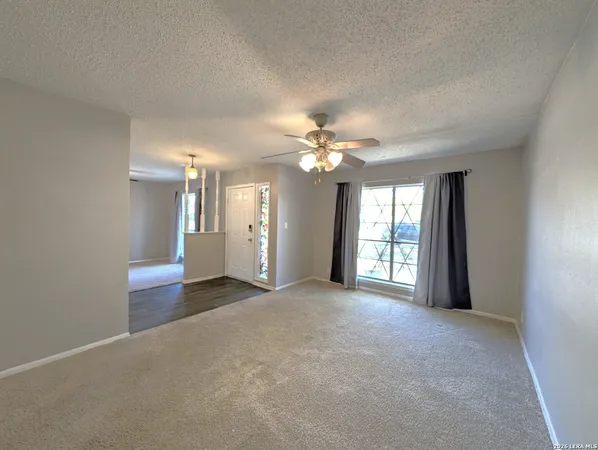 a view of a big room with windows and chandelier
