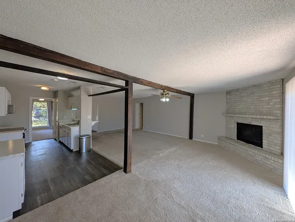an empty room with wooden floor and fireplace