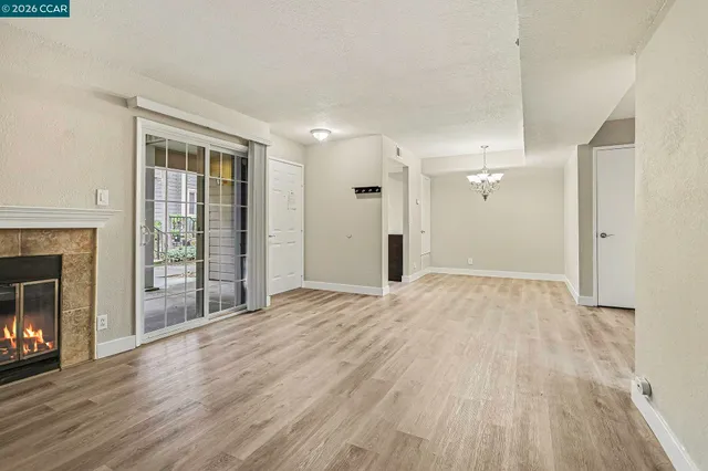 a view of empty room with wooden floor and fireplace