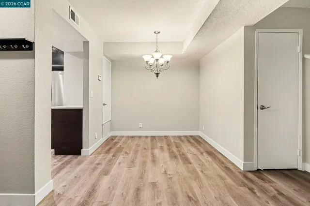 a view of a room with wooden floor closet and windows