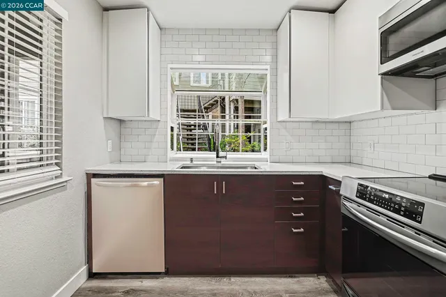 a kitchen with a sink window and cabinets