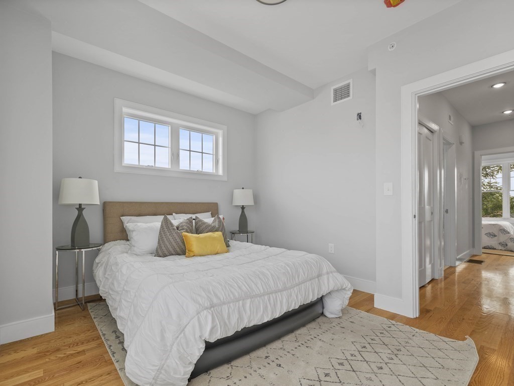 106-116 Main Street Everett, MA 02149 - Photo 17 of 24 a bedroom with a bed and wooden floor