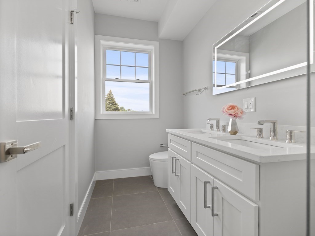 106-116 Main Street Everett, MA 02149 - Photo 19 of 24 a bathroom with a double vanity sink a toilet and a window
