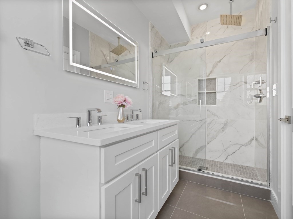 106-116 Main Street Everett, MA 02149 - Photo 20 of 24 a bathroom with a granite countertop sink a mirror a vanity and shower