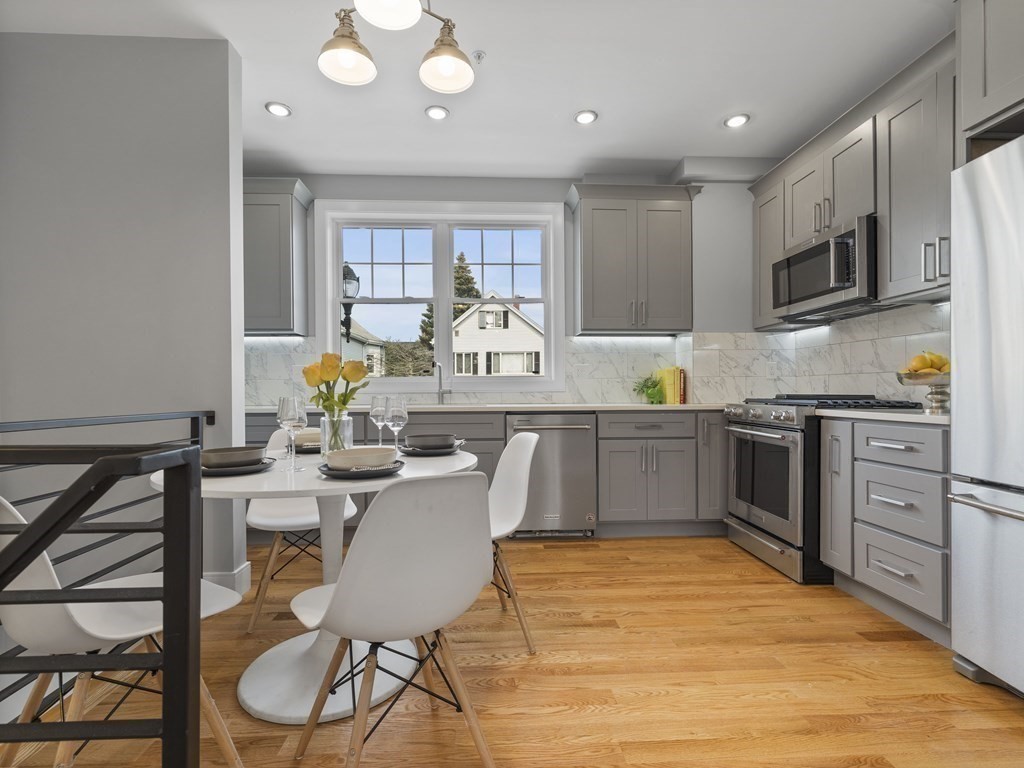106-116 Main Street Everett, MA 02149 - Photo 7 of 24 a kitchen with stainless steel appliances granite countertop a stove top oven a sink dishwasher and white cabinets with wooden floor