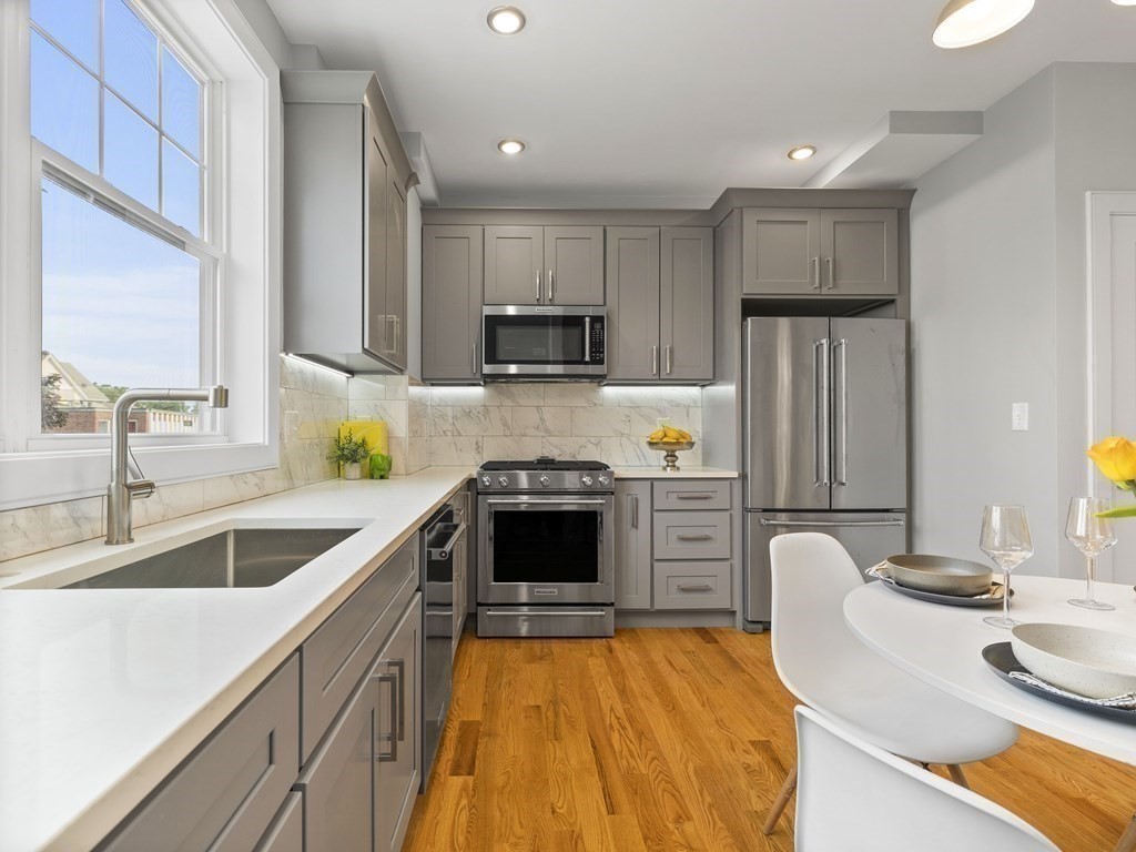 106-116 Main Street Everett, MA 02149 - Photo 8 of 24 a kitchen with refrigerator a stove and a sink with wooden cabinets