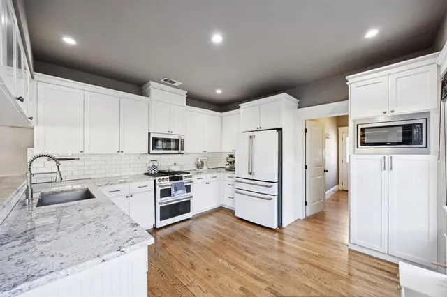a kitchen with stainless steel appliances granite countertop a refrigerator sink and microwave