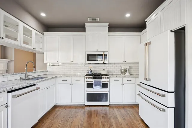 a kitchen with stainless steel appliances a stove a sink and a refrigerator