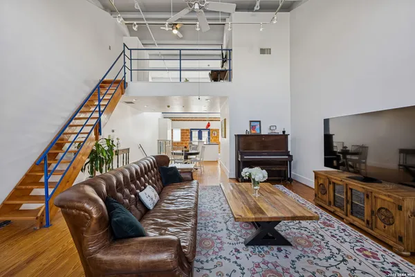 a living room with furniture flat screen tv and a lamp