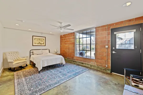 a spacious bedroom with a bed and wooden floor
