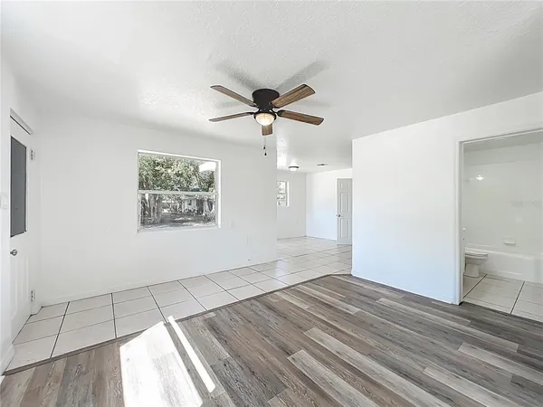 a view of a big room with wooden floor and a ceiling fan