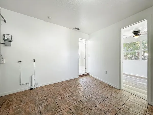 an empty room with wooden floor and a ceiling fan