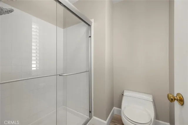 a white toilet sitting next to a shower