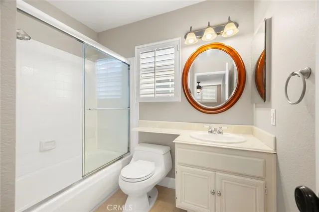 a bathroom with a sink a toilet mirror and shower