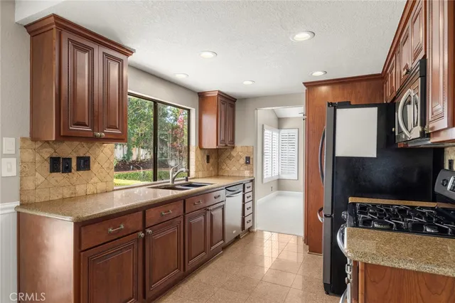 a kitchen with stainless steel appliances granite countertop a stove a sink and a microwave