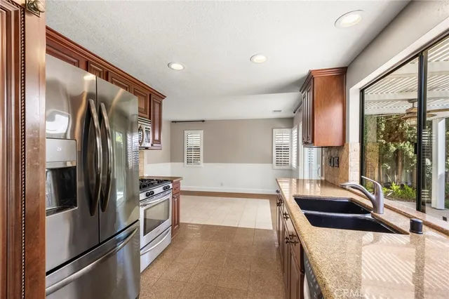 a kitchen with granite countertop a refrigerator and a sink