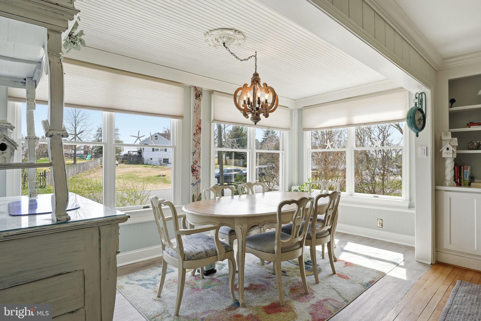 7806 Summit Drive Pasadena, MD 21122 - Photo 14 of 74 a view of a dining room with furniture large windows and wooden floor