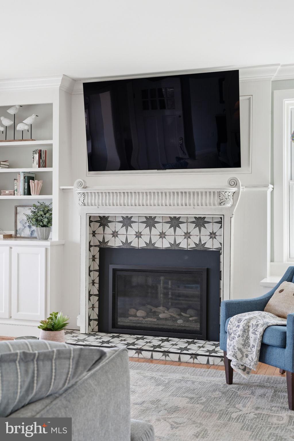 7806 Summit Drive Pasadena, MD 21122 - Photo 9 of 74 a living room with a fireplace and a flat screen tv