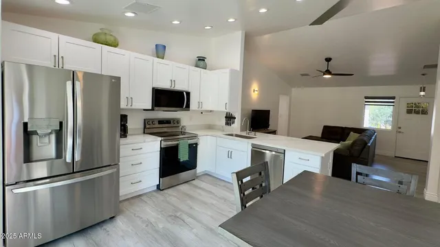 a kitchen with a refrigerator cabinets and wooden floor