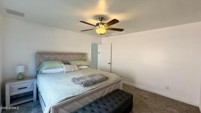 a bedroom with a bed and a ceiling fan