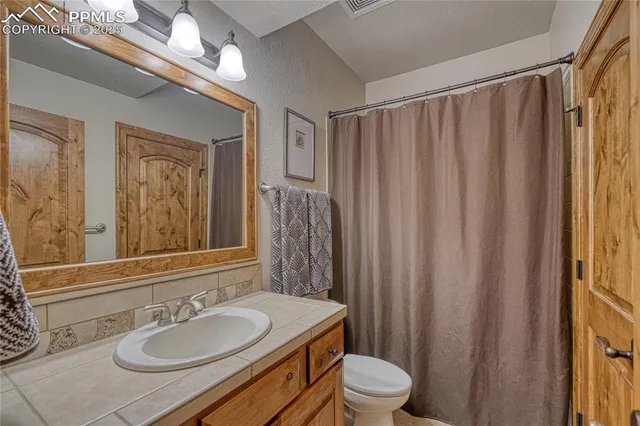 a bathroom with a double vanity sink toilet and a mirror