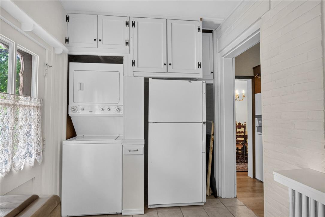 765 East Macada Road Bethlehem, PA 18017 - Photo 20 of 46 A compact laundry and kitchen area, featuring a stacked washer and dryer, and a refrigerator with ample storage above.