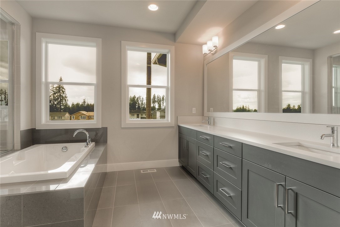 21819 33rd Drive Southeast, Unit 29 Bothell, WA 98021 - Photo 15 of 25 a bathroom with a granite countertop tub sink and mirror