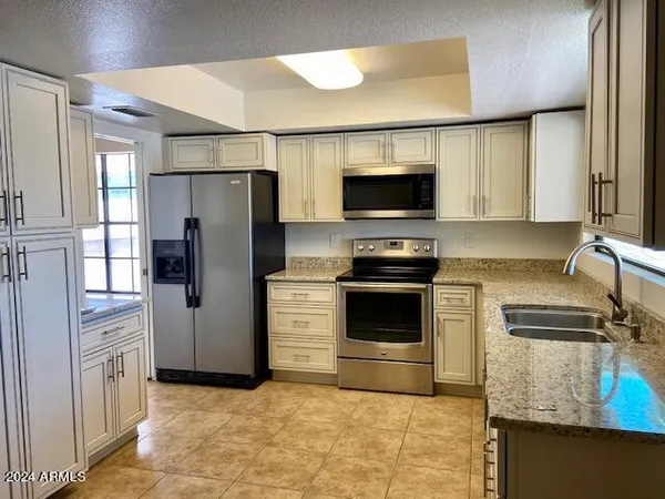 a kitchen with stainless steel appliances a refrigerator stove and microwave