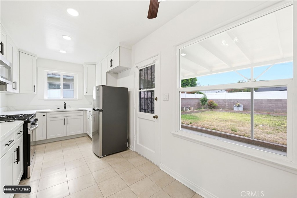 10539 Gridley Road Santa Fe Springs, CA 90670 - Photo 12 of 29 a kitchen with a refrigerator an oven a sink and a large window