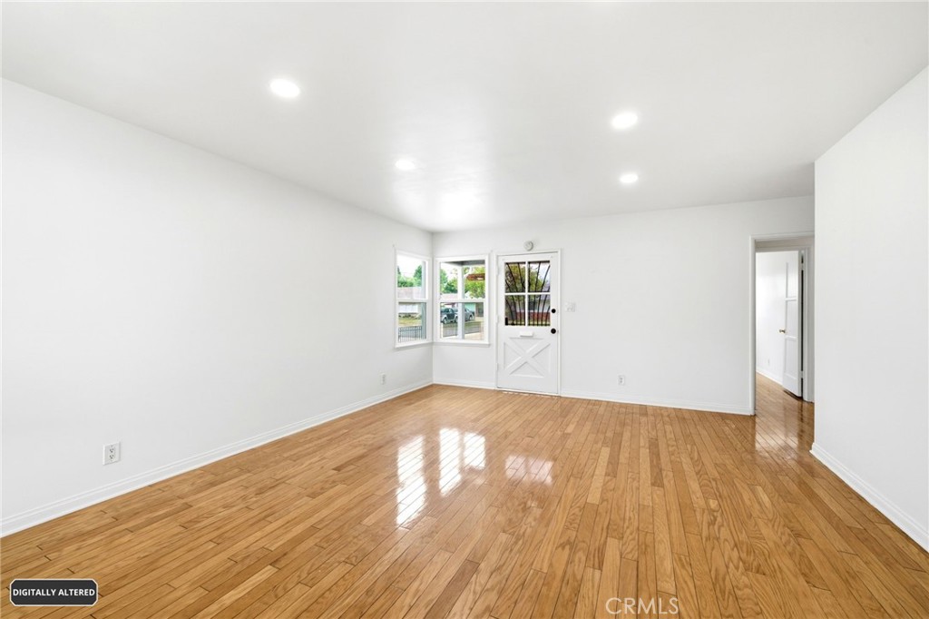 10539 Gridley Road Santa Fe Springs, CA 90670 - Photo 4 of 29 an empty room with wooden floor and windows
