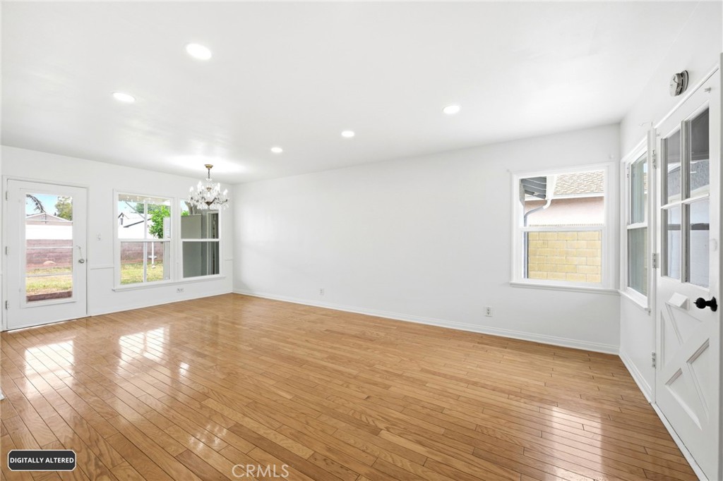10539 Gridley Road Santa Fe Springs, CA 90670 - Photo 7 of 29 an empty room with wooden floor and windows