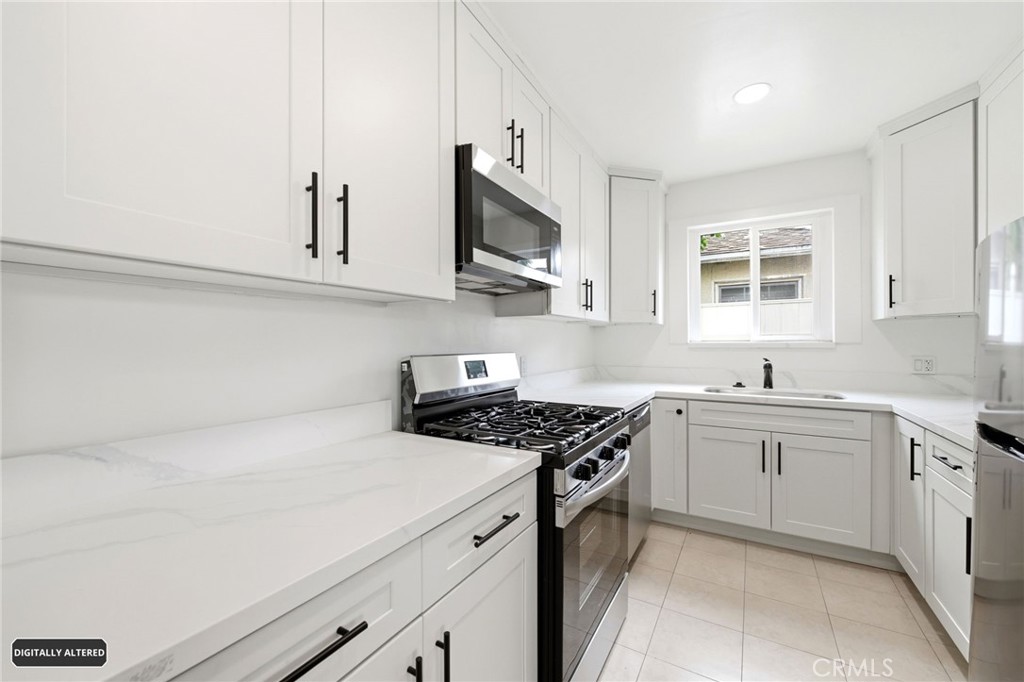 10539 Gridley Road Santa Fe Springs, CA 90670 - Photo 10 of 29 a kitchen with stainless steel appliances a sink stove and microwave