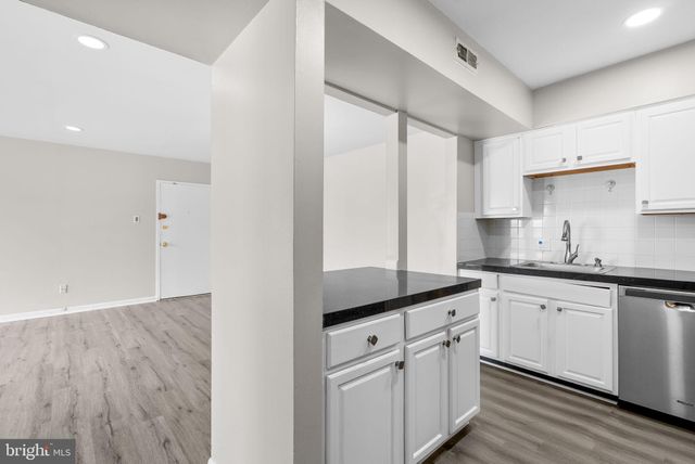 a kitchen with granite countertop white cabinets white appliances and sink