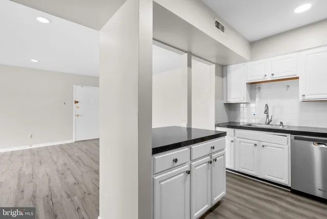 a kitchen with granite countertop white cabinets white appliances and sink