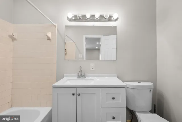 a bathroom with a sink a toilet and mirror
