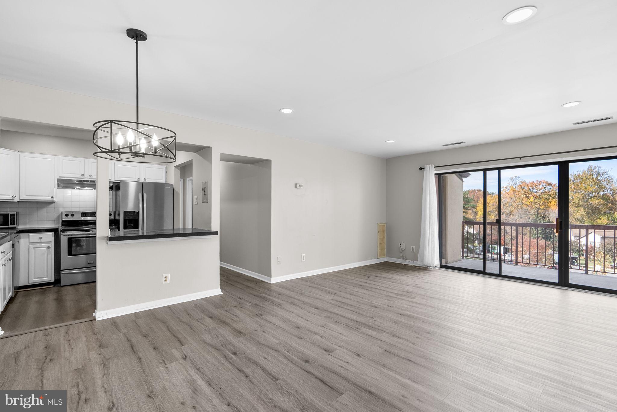 10121 Prince Place, Unit 30210B Upper Marlboro, MD 20774 - Photo 8 of 24 a view of a room with stainless steel appliances wooden floors and kitchen view