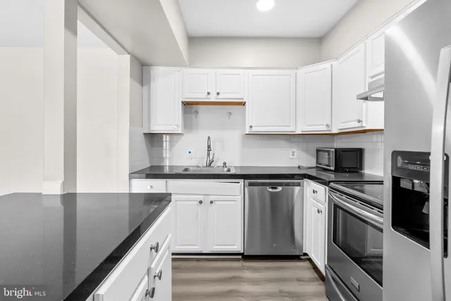 a kitchen with stainless steel appliances granite countertop a sink stove and cabinets