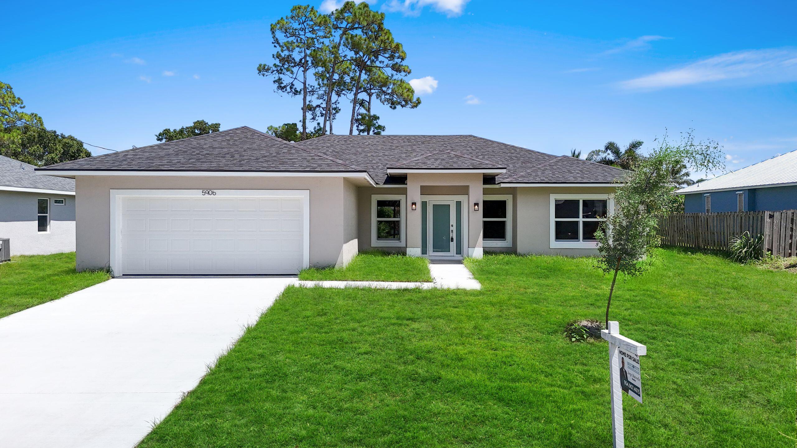4611 Sunset Boulevard Fort Pierce, FL 34982 - Photo 2 of 28 a front view of a house with a yard and garage