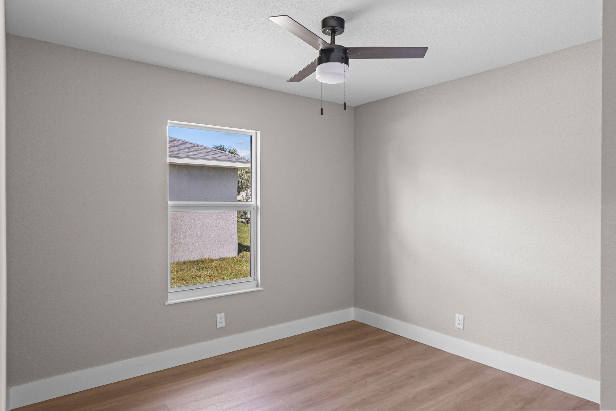 4611 Sunset Boulevard Fort Pierce, FL 34982 - Photo 21 of 28 a view of an empty room with a window and wooden floor