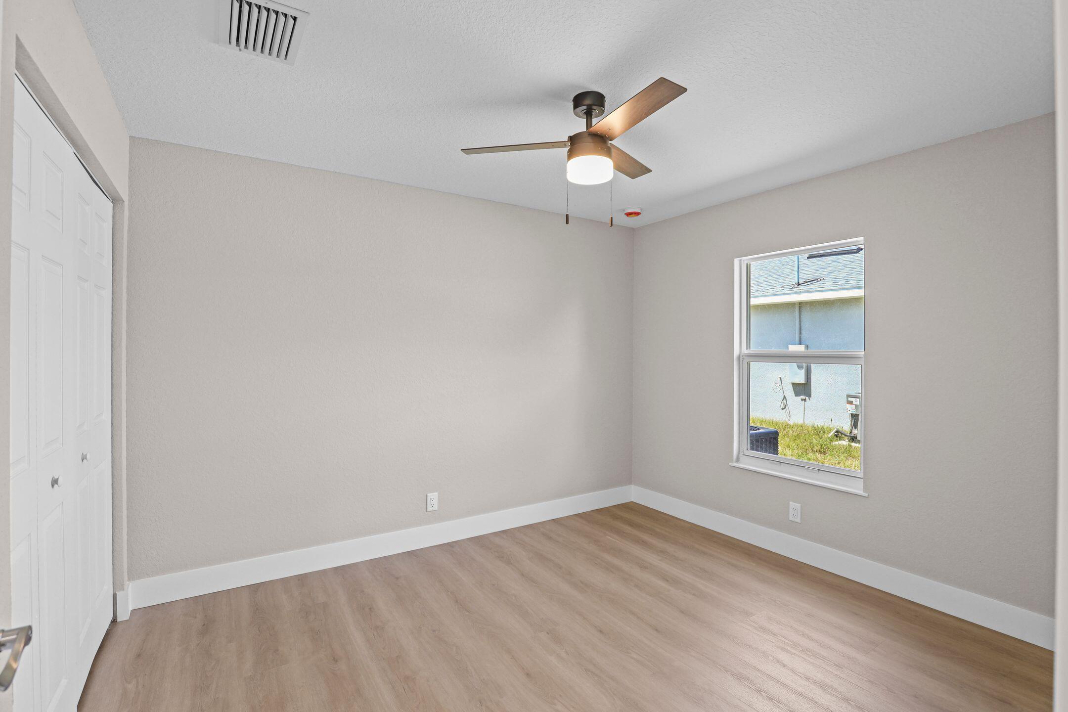 4611 Sunset Boulevard Fort Pierce, FL 34982 - Photo 22 of 28 wooden floor in an empty room with a window