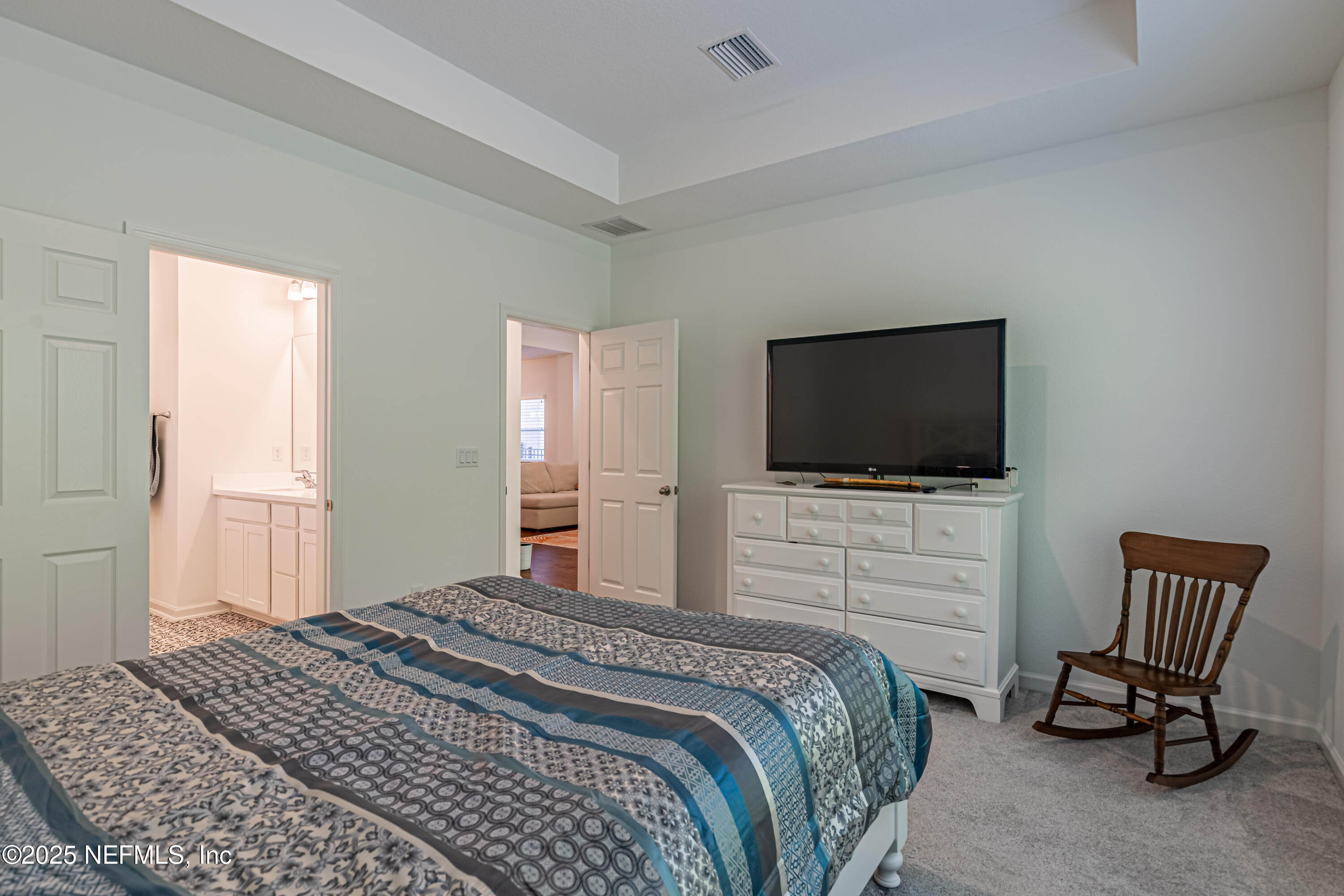 383 Windswept Way Street St. Augustine, FL 32092 - Photo 23 of 34 a bedroom with a bed chair and a flat screen tv