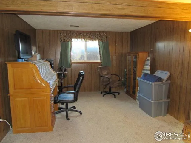 a view of a workspace with furniture and a window