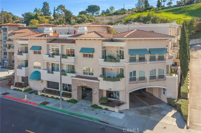 a front view of a building with a garden and plants