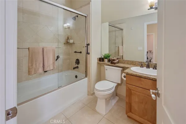 a bathroom with a granite countertop sink a mirror and a toilet