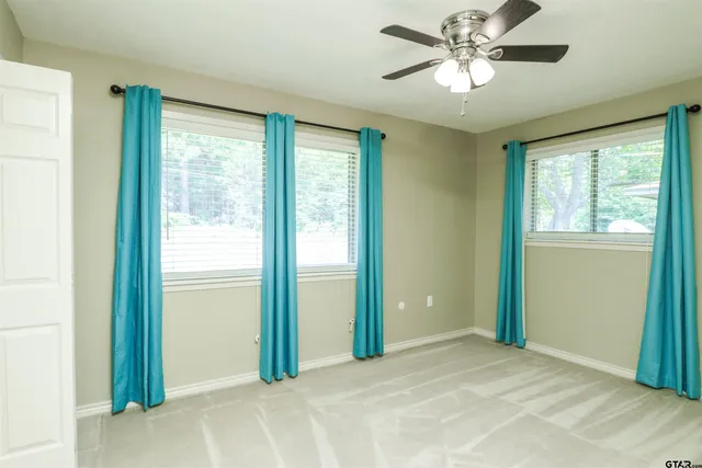 a view of a room with a ceiling fan and a large window