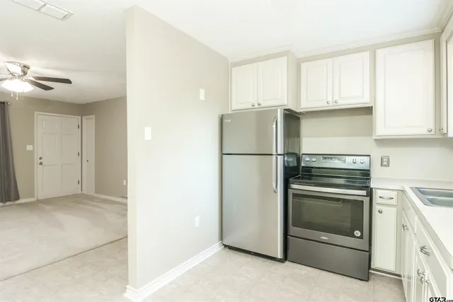 a kitchen with a refrigerator sink and cabinets