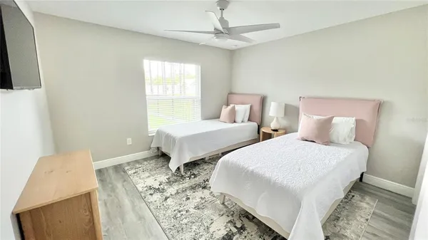 a bedroom with two beds and a chandelier
