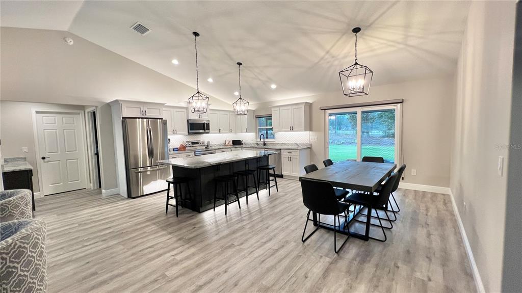 6944 Southwest 179th Ave Road Dunnellon, FL 34432 - Photo 3 of 19 a open kitchen with stainless steel appliances granite countertop a dining table chairs stove a refrigerator and cabinets
